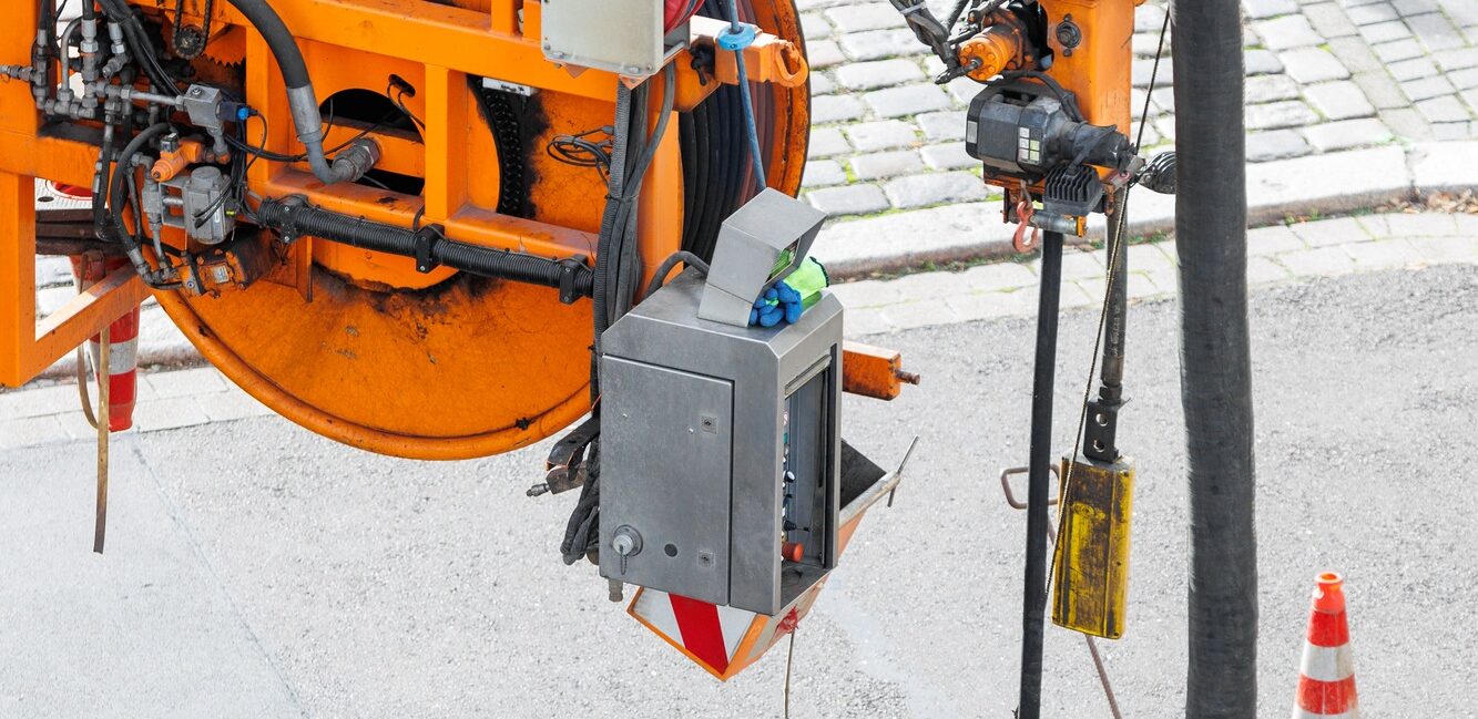 Pipe hose sewage truck car engine emptying city street sewerage manhole. Septic cleaning vacuum